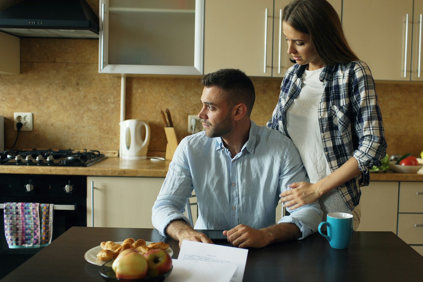 A couple going through paperwork at a kitchen table